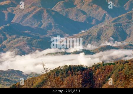 Belle vue panoramique aérienne de Garfagnana depuis San Pellegrino en Alpe, avec des couleurs d'automne et des nuages bas dans les vallées en dessous, Italie Banque D'Images