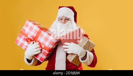 Le Père Noël souriant avec ses mains pleines de cadeaux pour noël Banque D'Images