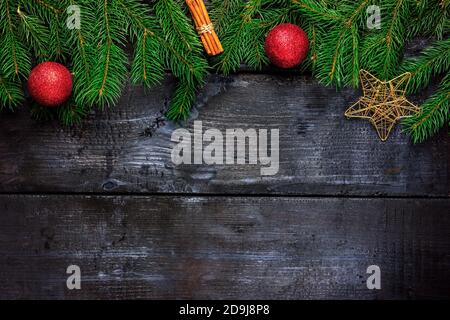 Branches de sapin avec bâtonnets de cannelle et boules de Noël sur un arbre noir. Vue de dessus. Cadre décoratif Banque D'Images