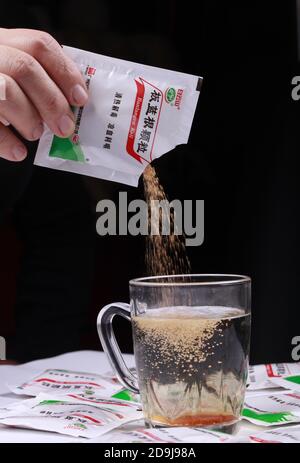 Dans cette photo non localisée, une personne verse un sac d'Isatis Root, également connu sous le nom de Ban LAN Gen, qui est largement utilisé en Chine, 19 octobre 2020. *** Cap local Banque D'Images