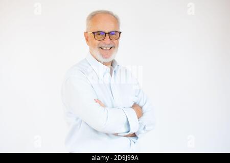 Portrait d'un homme âgé joyeux qui regarde l'appareil photo et qui sourit sur un fond blanc. Banque D'Images