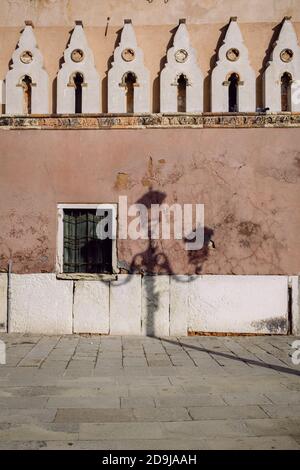 Une vieille lumière de rue traditionnelle ombre sur un mur à Venise avec des remparts médiévaux Banque D'Images