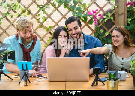 Jeunes amis filmant vidéo vlog pour la chaîne Web en ligne - heureux les gens du millénaire ayant le plaisir de faire le streaming en direct à l'aide de smartphone CAM et de l'ordinateur Banque D'Images