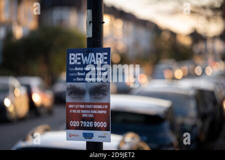 Une paire d'yeux regardent une rue résidentielle de banlieue, sur un panneau qui avertit les mordeurs de ne pas jeter des ordures sur cette rue dans le sud de Londres, le 4 novembre 2020, à Londres, en Angleterre. Banque D'Images