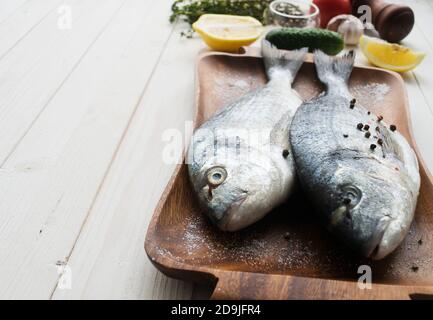 Fruits de mer. Deux truites arc-en-ciel crues marinées avec du citron vert, du poivre, des épices et du romarin sur bois. Concept de nourriture saine et de régime alimentaire. Banque D'Images