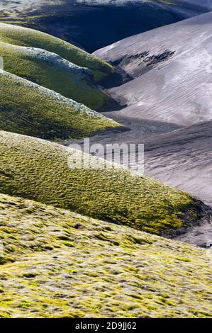 Un paysage ondulé contrastay d'un ancien ruisseau où les dunes volcaniques noires rencontrent les dunes vertes couvertes de mousse. Région volcanique de Lakagigar, Islande. Coucher de soleil tim Banque D'Images