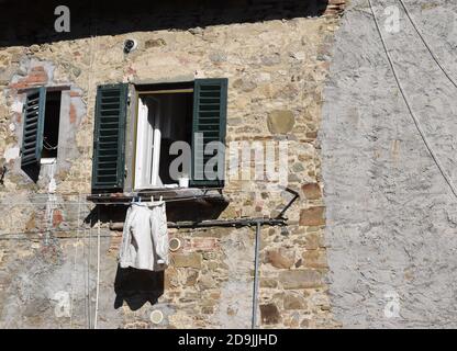 L'exposition quotidienne simple montre la beauté de l'ancien médiéval Mur en pierre avec fenêtres en Toscane Italie Banque D'Images