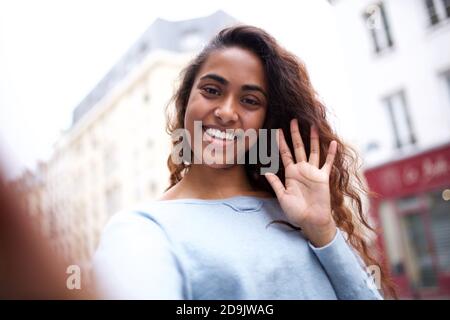 Portrait bonne jeune femme indienne souriante et emportant le selfie ville Banque D'Images