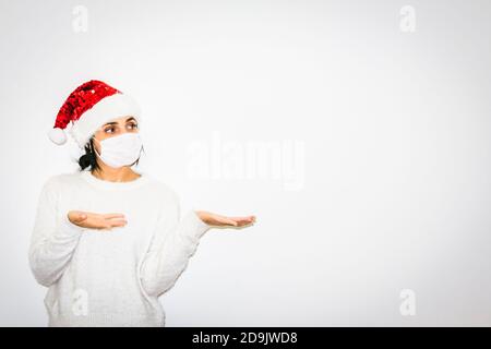 Mignonne caugausienne dans la tenue de Noël montre les mains à l'espace blanc droit. Concept d'espace vierge de publicité et de salutations. Banque D'Images