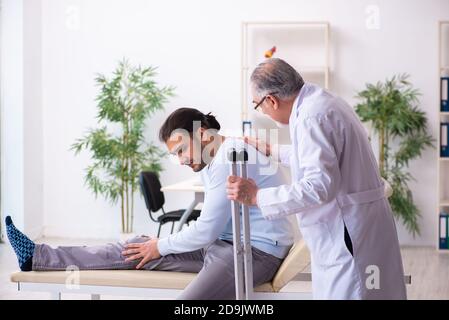 Un homme blessé à la jambe se rendant chez un ancien médecin ostéopathe Banque D'Images