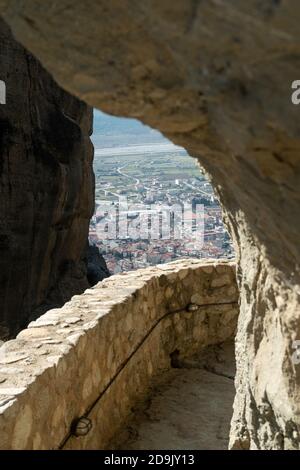 Vue depuis un passage de temple de montagne Meteora donnant sur la ville historique de Kalabaka ( Καλαμπάκα ), site classé au patrimoine mondial de l'UNESCO, Grèce centrale. Banque D'Images