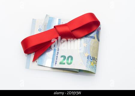 Billets et pièces en euros décorés d'arcs-cadeaux; donner de l'argent aux fêtes de Noël. Quand vous ne savez pas quoi donner, vous donnez de l'argent. Le meilleur cadeau, Banque D'Images