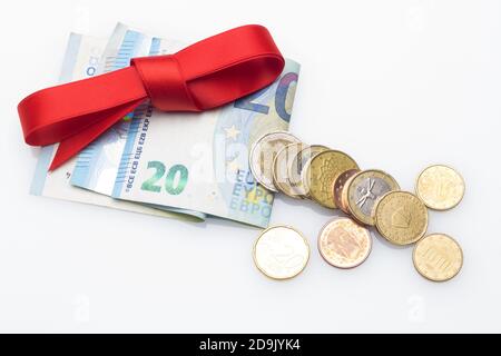 Billets et pièces en euros décorés d'arcs-cadeaux; donner de l'argent aux fêtes de Noël. Quand vous ne savez pas quoi donner, vous donnez de l'argent. Le meilleur cadeau, Banque D'Images