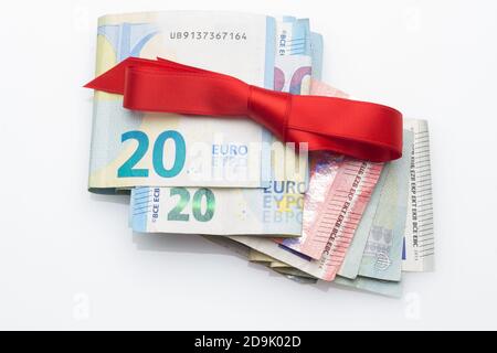 Billets et pièces en euros décorés d'arcs-cadeaux; donner de l'argent aux fêtes de Noël. Quand vous ne savez pas quoi donner, vous donnez de l'argent. Le meilleur cadeau, Banque D'Images