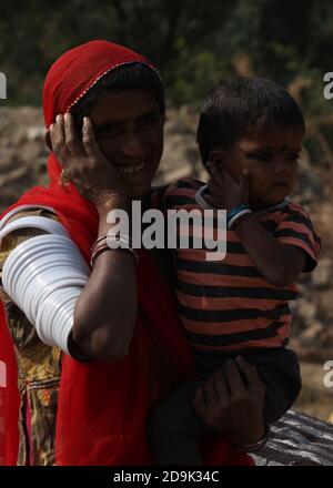 Mère tzigane avec ses enfants qui s'amusent au travail et sa vie nomade. Elle travaille avec toute la famille et n'a pas de maison. Elle est femme indienne banjara avec grâce. Banque D'Images