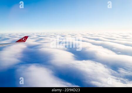 Logo Turkish Airlines sur l'aile droite. Vue depuis la fenêtre avion. Horizon bleu au-dessus des nuages dans l'océan Atlantique. Voyage d'Istanbul à New York Banque D'Images