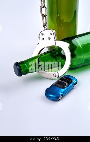 Flacons verticaux avec menottes et voiture miniature. Banque D'Images