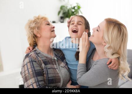 Portrait de trois générations de femmes regardent l'appareil photo posant pour la photo de famille, petite fille mignon hug maman et granny profiter du temps à la maison, souriant Banque D'Images