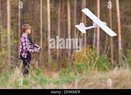 Le jeune homme contrôle un avion radiocommandé de son propre assemblage. Banque D'Images