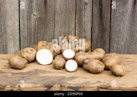 Yam ou Kachil (Dioscorea alata) sur fond de bois Banque D'Images