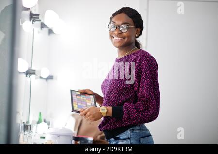 Femme afro-américaine maquilleuse au salon de beauté. Banque D'Images