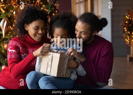 Gros plan bonne famille afro-américaine déballage cadeau de Noël Banque D'Images