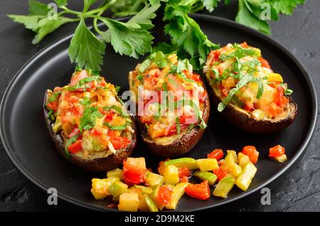 Aubergines farcies savoureuses avec légumes et parmesan sur l'assiette, vue rapprochée Banque D'Images