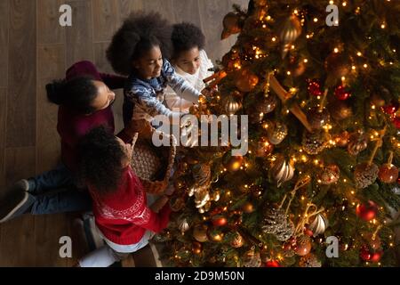 Vue de dessus famille afro-américaine avec des enfants décorant arbre de Noël Banque D'Images