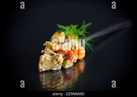 caviar d'aubergine d'été cuit avec des légumes sur fond noir Banque D'Images