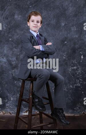 Adorable écolier habillé en costume portrait de studio Banque D'Images