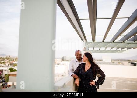 Couple multiracial de la fin des années quarante embrassant au coucher du soleil à San Diego Banque D'Images