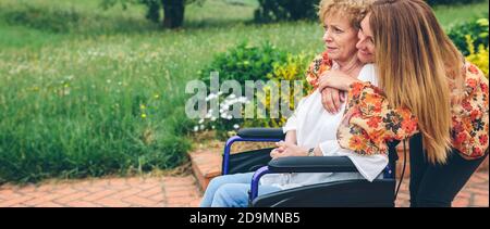 Hauts femme dans un fauteuil roulant avec sa fille Banque D'Images