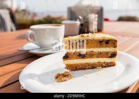 Gâteau aux carottes et à la citrouille avec de la crème de café dans une coupe sur l'assiette.délicieux gâteau aux carottes en tranches.tranche de gâteau sur une soucoupe blanche, décorée de noix, Banque D'Images