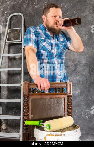 Un contremaître barbu plein de joie a une pause avec une bouteille de bière portrait de studio Banque D'Images