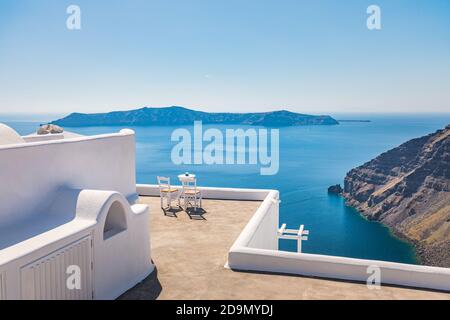 Architecture blanche sur l'île de Santorin, Grèce. Restaurant extérieur sous un paysage fantastique de coucher de soleil, chaises couple. Vue romantique, vacances d'été Banque D'Images