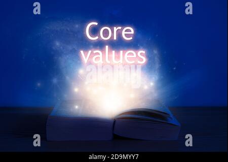 Livre ouvert avec inscription des valeurs fondamentales. La lumière vient du livre ouvert avec les valeurs fondamentales des mots. Banque D'Images