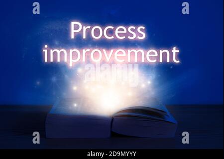 Livre ouvert avec inscription pour l'amélioration des processus. La lumière provient d'un livre ouvert avec des mots amélioration du processus. Banque D'Images
