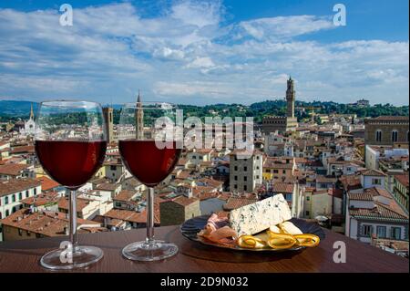 Deux verres de vin avec fromage et en-cas à la viande avec vue depuis le dessus du centre-ville historique de Florence en Italie. Verre de vin rouge avec différents en-cas Banque D'Images