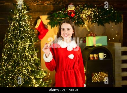 Bonne enfance. Fêtez la nouvelle année près de l'arbre de noël. Location de costumes d'arnival. Petite fille fête noël. Location d'accessoires de vacances. Services de location de décorations. Concept vacances d'hiver. Banque D'Images