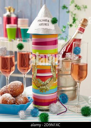 Verres de champagne rose à côté d'une bouteille décorée d'un ruban coloré Pour la Saint-Sylvestre DISPONIBLE pour le Royaume-Uni UNIQUEMENT - Veuillez appeler le bureau pour d'autres t Banque D'Images