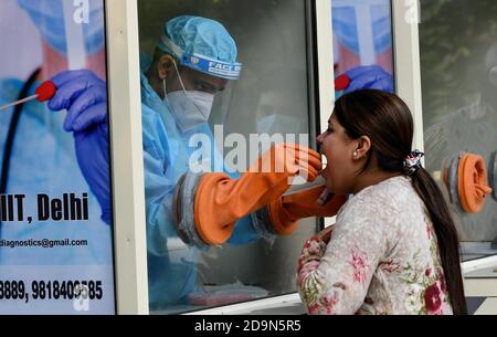 New Delhi, Inde. 6 novembre 2020. Un agent de santé recueille un écouvillon auprès d'une femme lors d'un test COVID-19 à New Delhi, en Inde, le 6 novembre 2020. Selon les dernières données publiées par le ministère fédéral de la Santé, le nombre de cas enregistrés par le COVID-19 en Inde a atteint 8,411,724 vendredi, alors que 47,638 nouveaux cas ont été enregistrés dans tout le pays au cours des 24 dernières heures. Credit: Partha Sarkar/Xinhua/Alamy Live News Banque D'Images