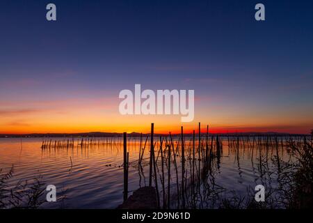 Magnifique coucher de soleil rom la Albufera à Valence (Espagne). Vous pouvez voir le matériel de pêche traditionnel utilisé par les pêcheurs locaux pour obtenir des anguilles et d'autres poissons. Banque D'Images