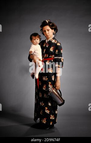 FEMME FATIGUÉE DES ANNÉES 1970 FEMME AU FOYER PORTANT UNE ROBE HOUSECOAT PORTANT BÉBÉ ET PERCOLATEUR CAFETIÈRE ROULEAUX DANS SES CHEVEUX REGARDANT L'APPAREIL PHOTO - KB11965 HAR001 HARS VÊTEMENTS INTÉRIEUR POT VISAGES STRESS NOSTALGIQUE PAIRE DÉPRESSION COULEUR DE SES MÈRES EXPRESSION TEMPS VIEUX OCCUPÉ NOSTALGIE OLD FASHION 1 SILLY JUVÉNILE STYLE VISAGE JEUNE ADULTE COMIQUE BÉBÉ INQUIÉTUDE FATIGUÉ STYLE DE VIE FEMMES ÉPUISÉ STUDIO SHOT MOODY ROBE ACCUEIL VIE COPIE ESPACE PLEINE LONGUEUR FEMMES FILLES PERSONNES PYJAMA EXPRESSIONS TROUBLÉ MATIN INQUIET TRISTESSE ROULEAUX OEIL CONTACT BRUNETTE DOMESTIQUES CURLERS HUMORISTIQUES ENDORMIS ET COMIQUE Banque D'Images