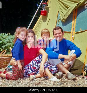 PORTRAIT DES ANNÉES 1970 D'UNE FAMILLE SOURIANTE DE QUATRE MÈRES, PÈRE, FILS FILLE REGARDANT L'APPAREIL PHOTO POSÉ À L'EXTÉRIEUR DE LEUR TENTE DE CAMPING - KC4523 HAR001 HARS QUATRE MOM VÊTEMENTS NOSTALGIQUE PAIRE 4 COULEUR MÈRES VIEUX TEMPS NOSTALGIE FRÈRE VIEILLE MODE SOEUR 1 JUVÉNILE STYLE VACANCES FILS HEUREUX FAMILLES JOIE STYLE DE VIE SATISFACTION FEMMES MARIÉES FRÈRES RURAL CONJOINT MARI SANTÉ COPIE ESPACE AMITIÉ PLEINE LONGUEUR DEMI-LONGUEUR FEMMES FILLES PERSONNES HOMMES CAMPING FRÈRES ET SŒURS PÈRES PARTENAIRE TEMPS HORS BONHEUR GAIE AVENTURE LOISIR ESCAPADE DADS LOISIRS EXTÉRIEUR LOISIRS FIERTÉ VACANCES FRÈRE Banque D'Images