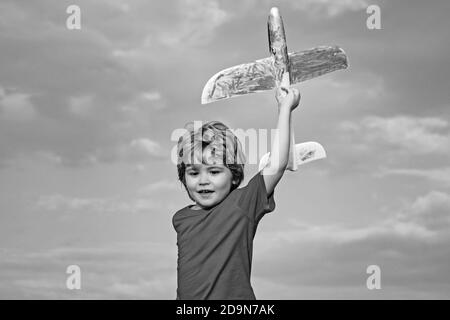 Garçon avec avion sur la prairie. L'été à la campagne. Le succès et le concept de chef d'enfant. Concept d'imagination de rêve d'enfance. Un pilote pour enfants s'amuser dans la prairie Banque D'Images