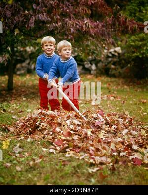 LES GARÇONS BLONDS DES ANNÉES 1980 VÊTUS DE MÊME DANS LE PANTALON ROUGE CHANDAIL BLEU RACLER LES FEUILLES D'AUTOMNE DANS LA COUR UN GARÇON REGARDE LA CAMÉRA AUTRE VISAGE DE FABRICATION - KJ6710 PHT001 HARS BLOND TRAVAIL D'ÉQUIPE JUMEAU PANTALONS IDENTIQUES DOUBLE FAMILLES STYLE DE VIE SATISFACTION FRÈRES SANTÉ VIE À LA MAISON NATURE COPIE ESPACE AMITIÉ DEMI-LONGUEUR MATCH RAKING MÂLES FRÈRES ET SŒURS OEIL CONTACT CORRESPONDANT MÊME BONHEUR HUMORISTIQUE AVENTURE CORVÉE ET EXCITATION DE LOISIRS LA FIERTÉ DE LA SAISON D'AUTOMNE LE LIEN ENTRE LES FRÈRES ET SŒURS LA COOPÉRATION CONCEPTUELLE RESSEMBLE À LA CROISSANCE DUPLIQUÉE LES JUVÉNILES ONT UNE APPARENCE SIMILAIRE À LA MÊME TOGETHNESS AUTOMNALE DE L'ETHNICITÉ CAUCASIENNE DE L'AUTOMNE FEUILLAGE ANCIEN Banque D'Images