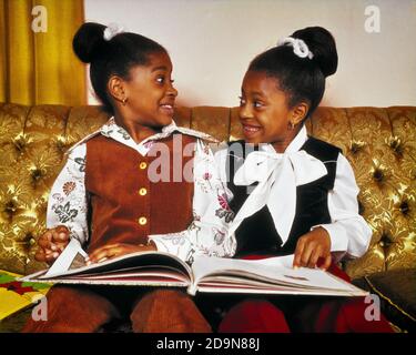 DES TWIN AFRO-AMÉRICAINS DES ANNÉES 1970 ASSIS SUR UN CANAPÉ POUR LIRE UN LIVRE AVEC DES EXPRESSIONS DU VISAGE EXPRESSIVES ET RÉAGISSANT - LIT KJ7736 HAR001 HARS STYLE COMMUNICATION TRAVAIL D'ÉQUIPE RIRE DOUBLE IDENTIQUE HEUREUX FAMILLES JOIE STYLE DE VIE FEMMES MAISON VIE COPIE ESPACE AMITIÉ DEMI-LONGUEUR MATCH FRÈRES ET SŒURS LES EXPRESSIONS DE SŒURS CORRESPONDANT AU MÊME BONHEUR GAI AFRO-AMÉRICAINS AFRO-AMÉRICAINS NOIR ETHNICITÉ LES FRÈRES SOURIENT EN TRAIN DE SE MOQUER JOYEUSEMENT LIÉ À LA RÉACTION DE RESSEMBLER À DES JEUNES DE CROISSANCE EN DOUBLE REGARDEZ COMME LE CLONE DE TOGETHERNESS EXPRESSIF HAR001 AFRO-AMÉRICAINS À L'ANCIENNE Banque D'Images