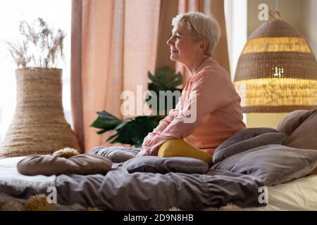 Femme caucasienne sécienne assise au lit Banque D'Images