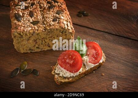 Tomates, basilic et fromage à la crème sur pain aux protéines maison de farine de lupin, son d'avoine et graines de citrouille, minceur avec bas carb ou régime cétogène, da Banque D'Images