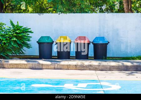 Poubelles de plusieurs couleurs pour séparer les types de déchets situés en public. Banque D'Images